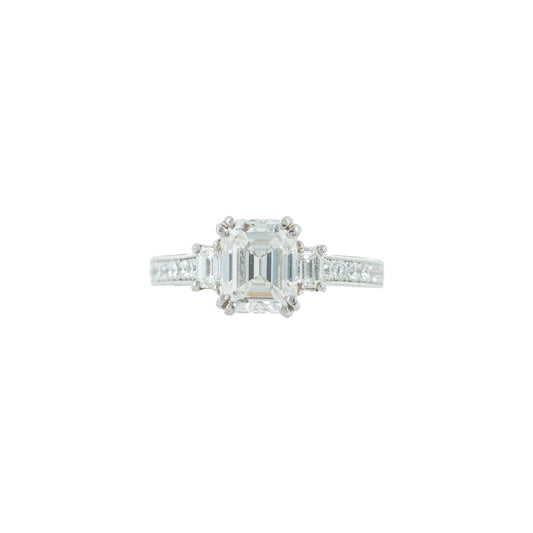 Diamond ring with a rectangular center stone on a white background